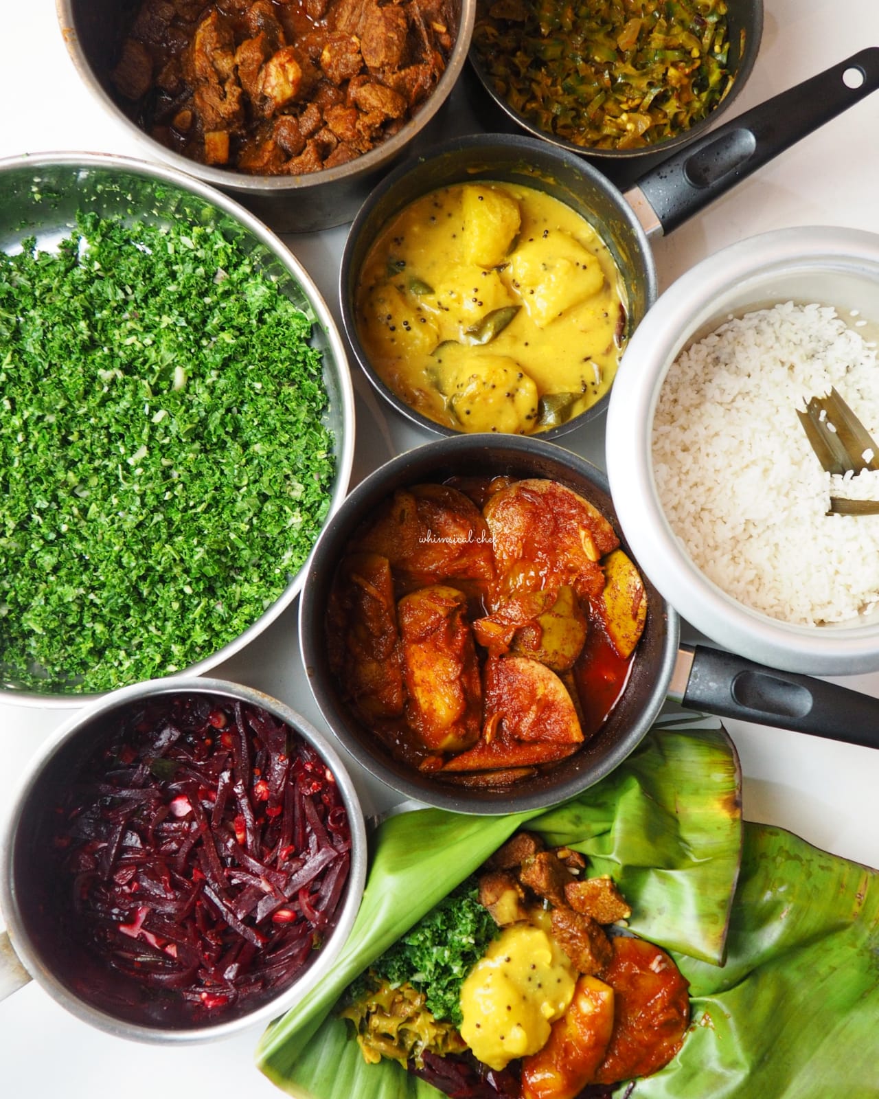 An overhead view of a Sri Lankan rice and curry spread, with many small dishes around a mound of rice.